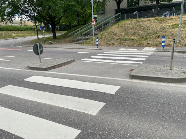 Es werden zwei Fahrbahnen überschritten; zwischen den Fahrbahnen befindet sich eine Fußgängerinsel